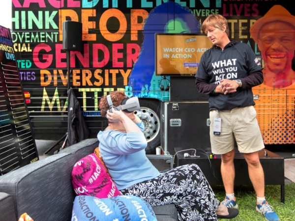Photo of a woman experiencing a virtual reality simulation in the inclusion lounge as part of the "Check Your Blindspots" mobile bus tour.